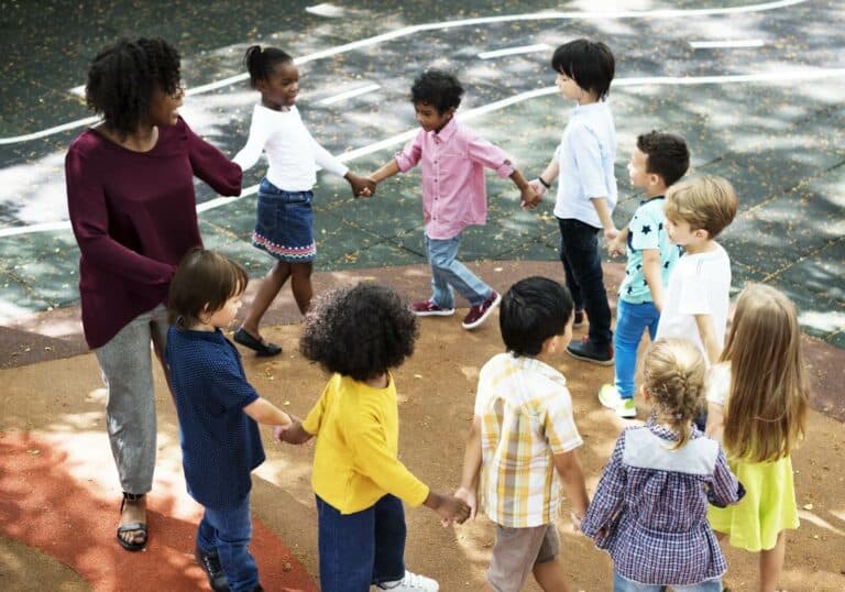 A kindergarten teacher playing with kids enrolled from marketing efforts