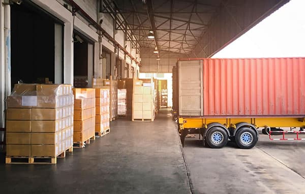 A semi truck waiting to be loaded with packages for transport.