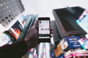 search engine optimization services image of a person surrounded by skyscrapers showing their smartphone's screen