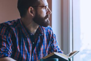 Man Reading Looking Out Window