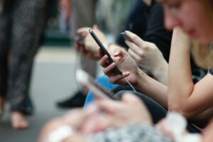 A line of people all holding Smartphones