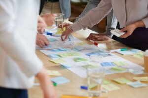 A group of people use paper and sticky notes to create a blog content calendar for their team.