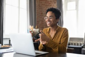 woman signing in front of laptop computer