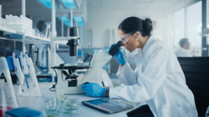 A lab tech using a microscope | life sciences digital marketing channels