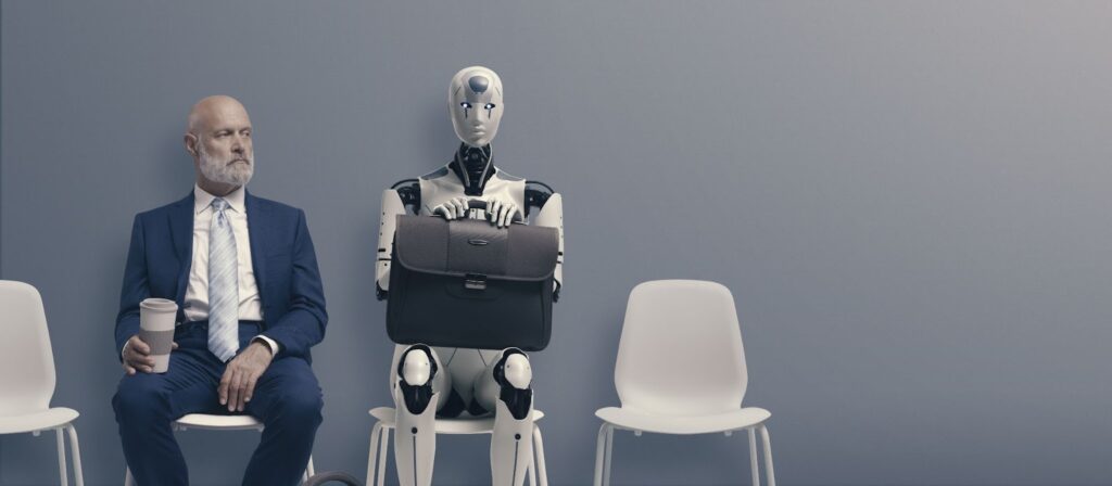 A man in a blue suit sits next to a robot holding a briefcase.